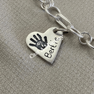 small silver heart charm with hand print impression and name inscribed on chain