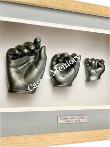 Three separate child hand casts in frame