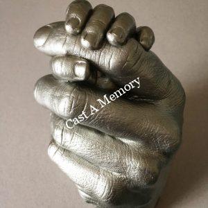 silver life cast of a mother and child's hands in a clasp