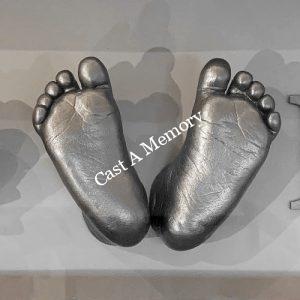 silver life cast of baby's feet mounted in a frame