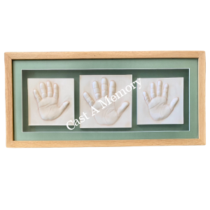 Clay hand impressions of siblings in a light wooden frame