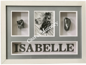 baby hand and foot cast in frame with black and white photo of child