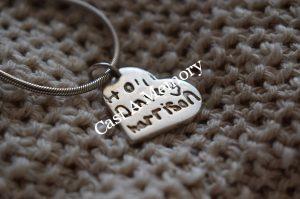 childrens name inscribed on a silver necklace charm