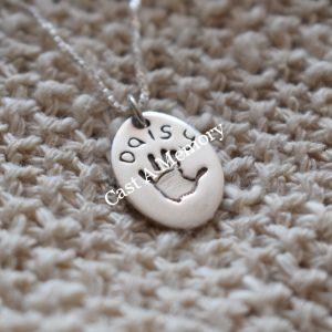 oval charm with handprint and name